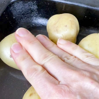 Press potatoes gently to pop the skins before roasting