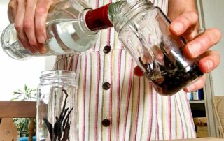 Pouring vodka into the jar to make vanilla extract