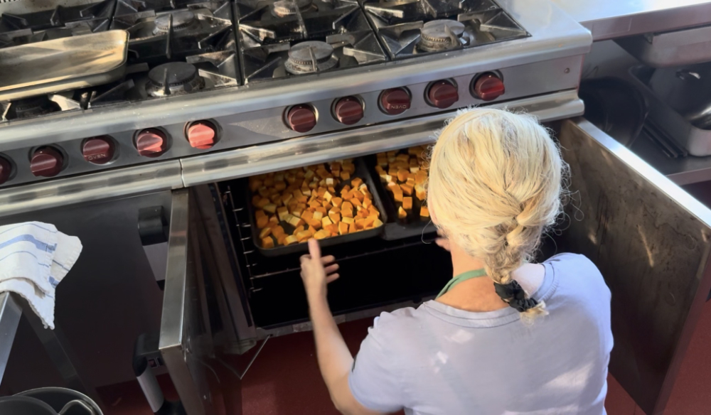 Anastasia putting butternut squash in the oven on retreat