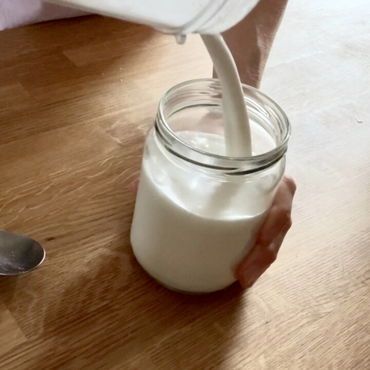 Pouring homemade coconut milk into a jar