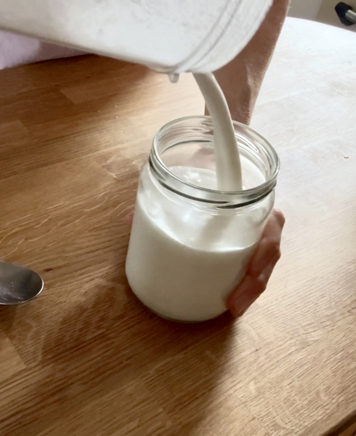 Pouring homemade coconut milk into a jar